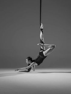 two women are performing aerial acrobatic tricks on the floor in black and white