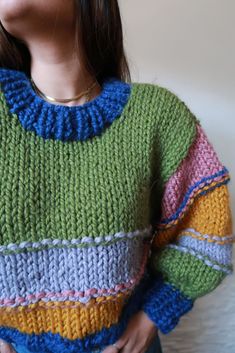 a woman wearing a multicolored knit sweater