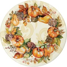 a white plate with pumpkins and pine cones on the front, surrounded by leaves