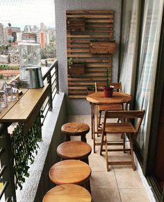 wooden tables and stools on a balcony overlooking the city