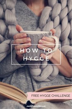 a woman is holding a coffee cup and reading a book with the title how to hygge