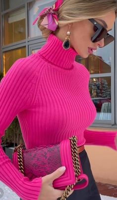 a woman in a pink sweater and sunglasses