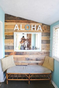 a wooden bench sitting in front of a mirror on the wall next to a window