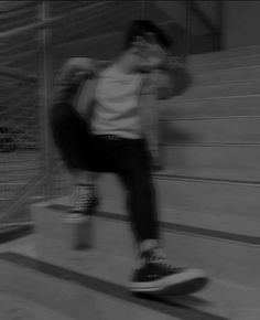 a man riding a skateboard down the side of a flight of stairs in black and white