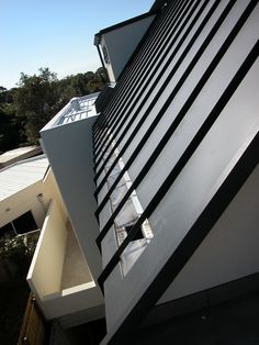 the side of a modern building with black and white stripes on it's sides