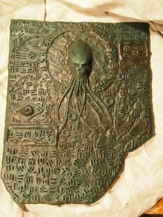 an old metal plaque with writing on it, and an octopus head in the middle