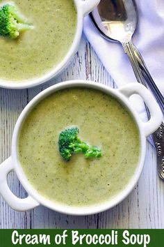 two white bowls filled with broccoli soup on top of a wooden table