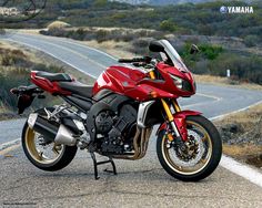 a red motorcycle is parked on the side of the road