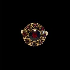 This incredible antique garnet cluster ring features a stunning array of deep red garnets set in a 14k yellow gold band. Features a natural garnet center stone, approx. 6.5mm Set in 14k yellow gold Accented with 8, 2.5mm garnet side stones Currently a size 4.75, sizable Because we do all our restoration work by hand we can offer a wide array of customization. If you have inquiries about sizing, alterations, or engraving, you can request a quote here. Resizing is available for an additional cost Antique Mens Jewelry, Engagement Ring Wedding Band, Men's Rings, Red Garnet, Gold Band, Antique Rings, Buying Jewelry, Cluster Ring, Solitaire Engagement Ring