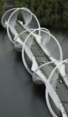 an aerial view of a bridge with cars driving on it and trees in the background