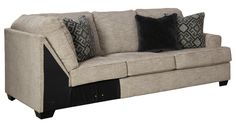 a beige couch with black and gray pillows on top of it's armrests