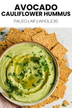 avocado cauliflower hummus in a bowl surrounded by tortilla chips