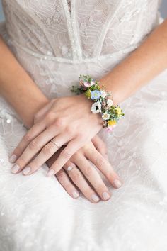 a woman in a wedding dress holding her hand on the other side of her arm