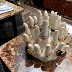 a bunch of rings that are sitting on top of a table in a room with marble counter tops