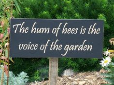 a sign that says the humm of bees is the voice of the garden