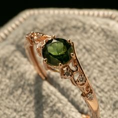 a close up of a ring with a green stone