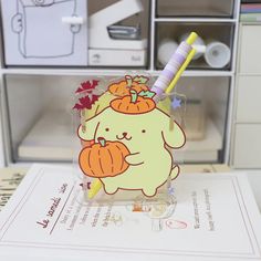 a clear box with a cartoon bear holding two pumpkins and a toothbrush in it