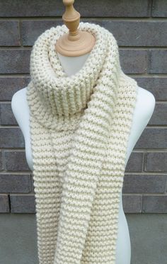 a white knitted scarf sitting on top of a mannequin