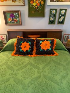 a bed with two pillows and pictures on the wall