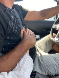 two people sitting in a car holding hands