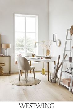 a living room with white walls and wooden floors, along with a ladder that is leaning up against the wall