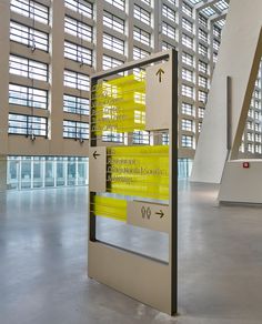 an airport lobby with large windows and yellow signs