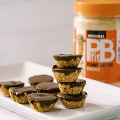 peanut butter cups stacked on top of each other in front of a jar of peanut butter