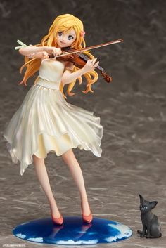 a figurine is playing the violin with a black cat behind her on a table