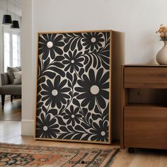 a black and white floral design is on display in the corner of a living room