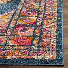 an area rug with colorful colors and designs on the floor in front of a wooden floor