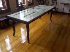 a glass table sitting on top of a hard wood floor