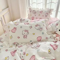 a hello kitty bed set with pink and white sheets, pillowcases and pillows