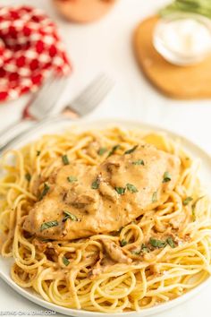 a white plate topped with pasta covered in gravy