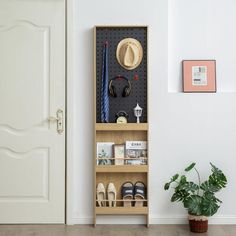 a wooden shelf with shoes and hats on it next to a potted plant in front of a door