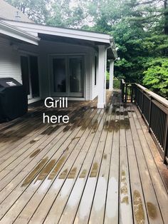 a wooden deck with grill on it and the words grill here overlayed in white