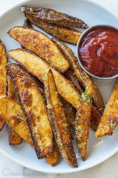 baked french fries with ketchup on a white plate, ready to be eaten