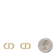 two small gold earrings with the letter d on each side and one smaller diamond in the middle