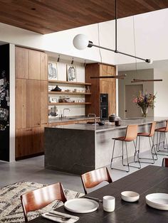 an open kitchen and dining room area with modern furniture