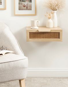 a white chair sitting in front of a wall with pictures on it and a book