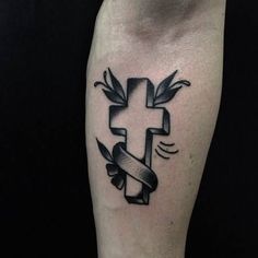 a black and white photo of a cross tattoo on the leg