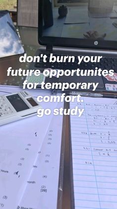 a laptop computer sitting on top of a desk next to papers and calculator