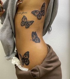 a woman with butterfly tattoos on her stomach