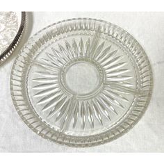 a clear glass plate sitting on top of a table next to a silver platter