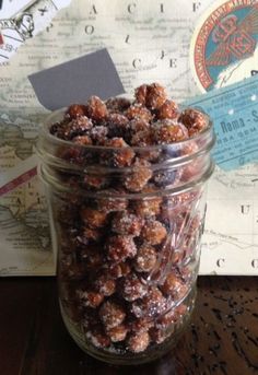 a jar filled with chocolate covered donuts sitting on top of a wooden table next to a map