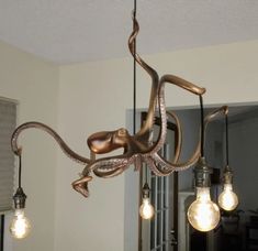 an octopus chandelier hanging from a ceiling in a room with several light bulbs