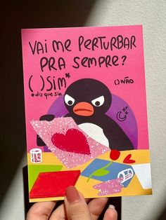 a person holding up a card with a penguin on it