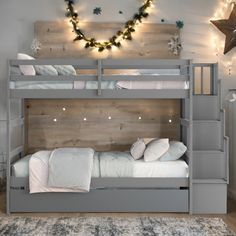 a bunk bed with stairs and lights on the wall in a room decorated for christmas