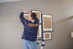 a man is painting the wall in his living room