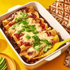 a casserole dish filled with taco meat, cheese and salsa on a wooden platter