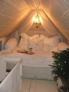 a white bed sitting in a bedroom next to a plant